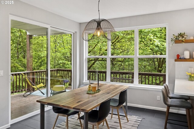 dining room featuring dark tile patterned floors and baseboards