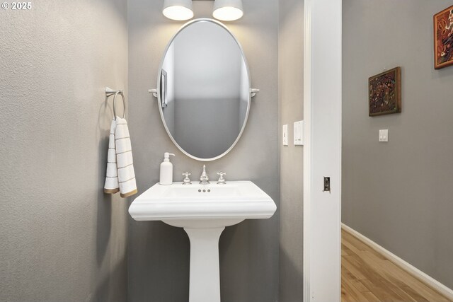 bathroom with baseboards and wood finished floors