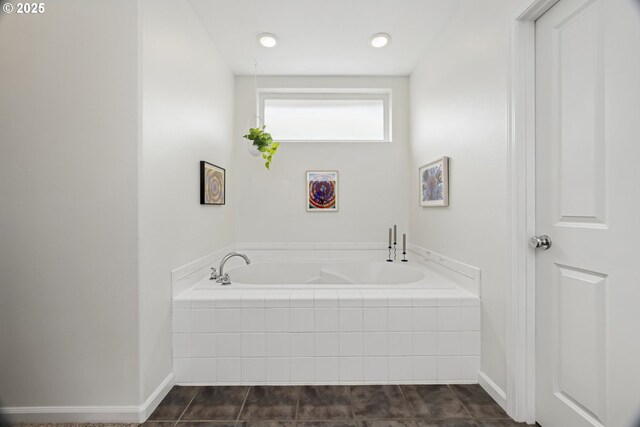 bathroom with baseboards and a bath
