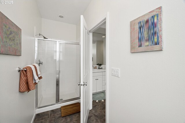 bathroom featuring vanity, tile patterned floors, baseboards, and a stall shower
