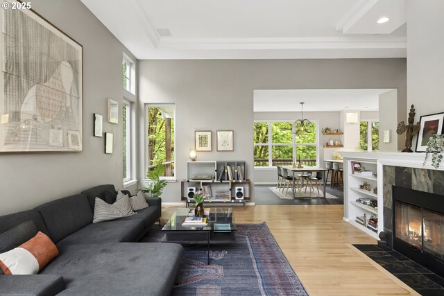 living room featuring a tiled fireplace, plenty of natural light, recessed lighting, and wood finished floors
