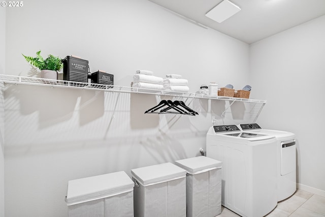 washroom with laundry area, baseboards, and washing machine and clothes dryer