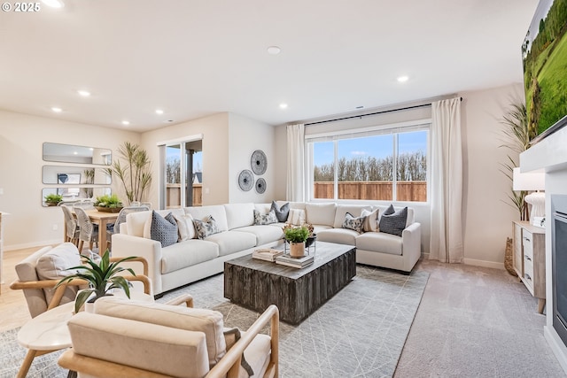 living area with baseboards, light carpet, and recessed lighting