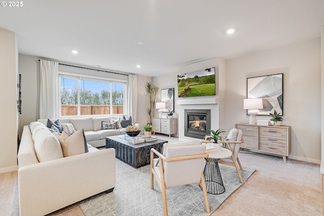 living room with recessed lighting, baseboards, and a glass covered fireplace