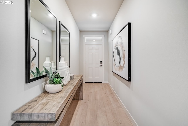 doorway with light wood-type flooring and baseboards