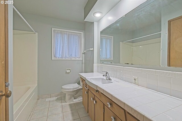bathroom with vanity, bathing tub / shower combination, toilet, tile patterned floors, and tasteful backsplash