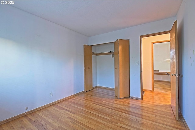 unfurnished bedroom with baseboards and light wood-style floors