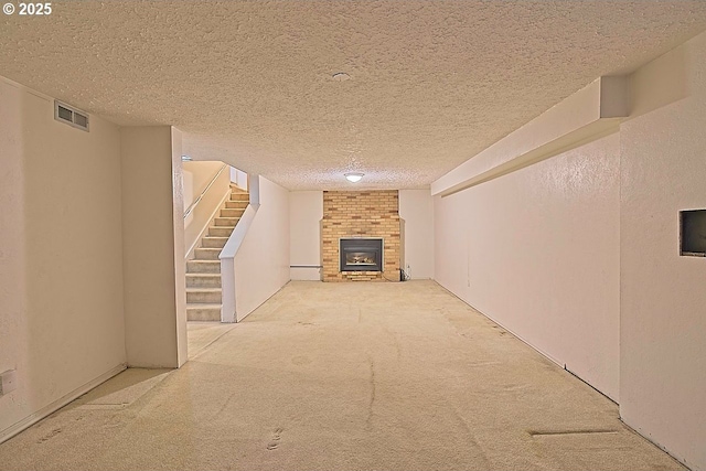 hallway featuring stairs, a textured ceiling, visible vents, and carpet