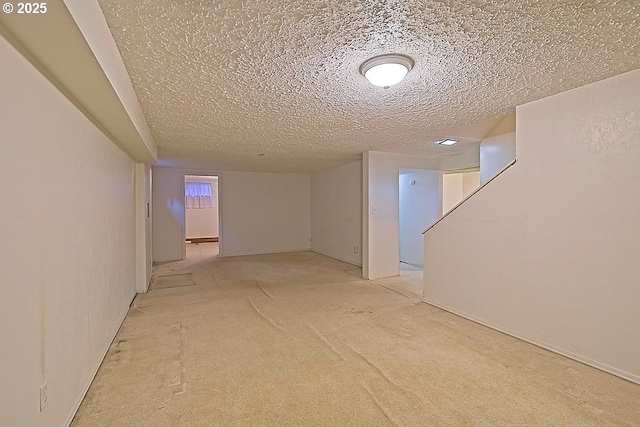 finished basement featuring a textured ceiling and light colored carpet