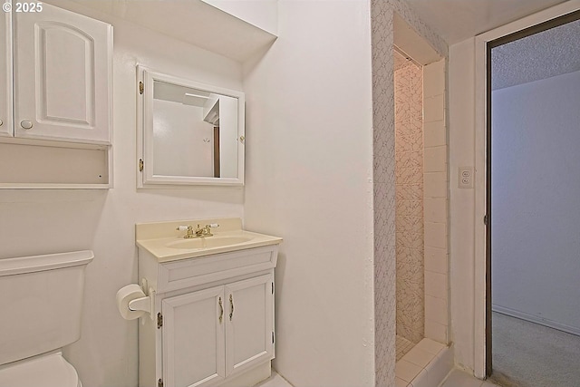bathroom with vanity, a shower stall, and toilet