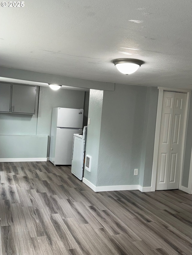 1605 4th St, Salem, OR 97301 - below grade area featuring freestanding refrigerator, dark wood-style floors, a textured ceiling, and baseboards
