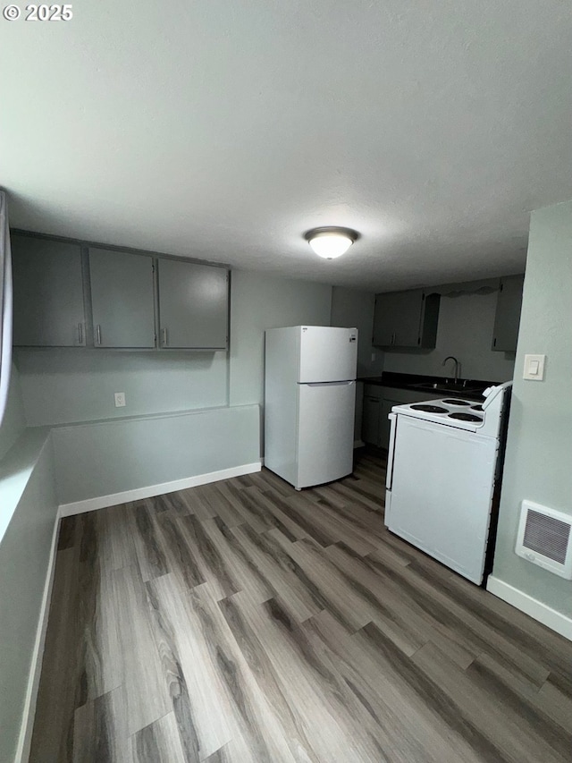 1605 4th St, Salem, OR 97301 - kitchen featuring white appliances, gray cabinetry, a sink, and baseboards