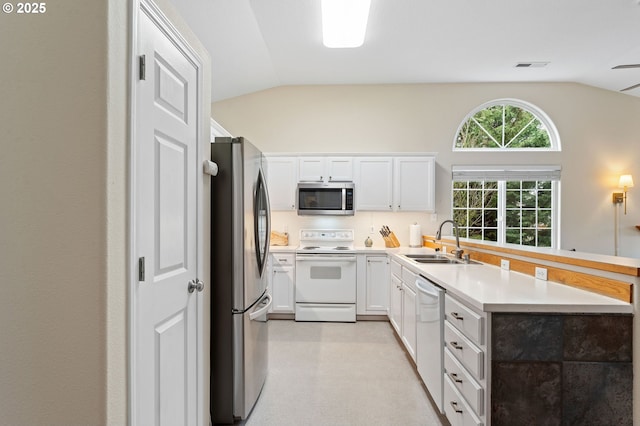 kitchen with a sink, visible vents, lofted ceiling, and appliances with stainless steel finishes