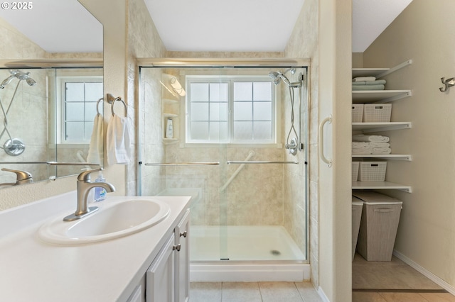 bathroom featuring tile patterned flooring, vanity, and a stall shower