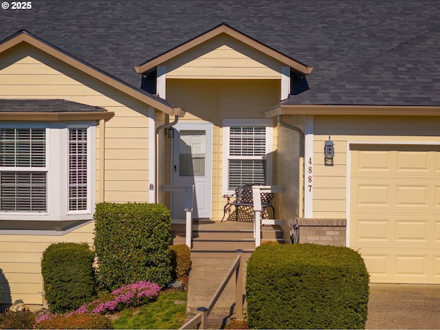 view of front of house featuring a garage and roof with shingles