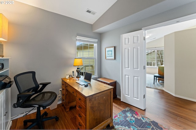 office with vaulted ceiling, wood finished floors, visible vents, and baseboards