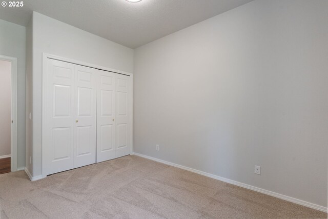 1225 NE 3rd Ave, Hillsboro, OR 97124 - unfurnished bedroom featuring light carpet and a closet