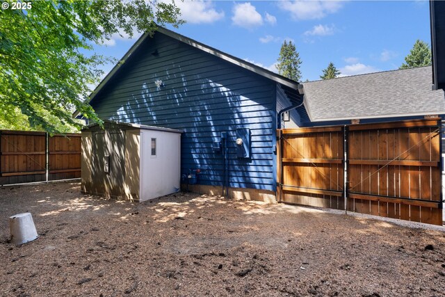 1225 NE 3rd Ave, Hillsboro, OR 97124 - back of property featuring a fenced backyard, a shingled roof, a shed, and a gate