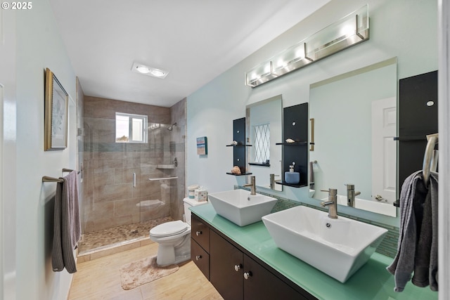 bathroom with tile patterned floors, vanity, toilet, and a shower with door