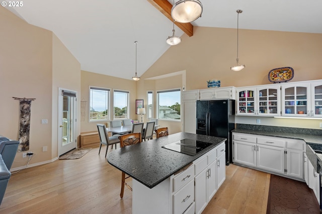 kitchen featuring beam ceiling, white cabinetry, a center island, and hanging light fixtures