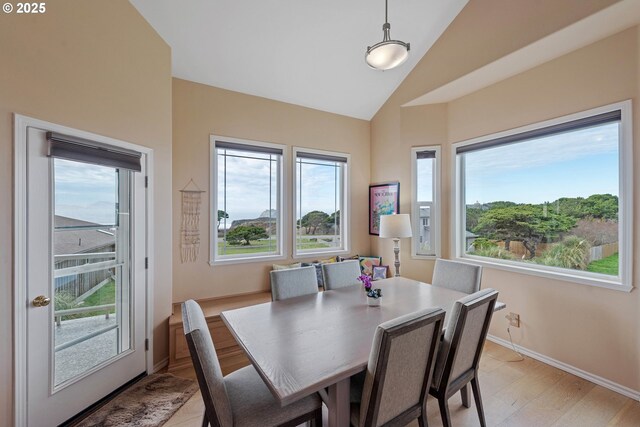 dining area with light hardwood / wood-style floors and lofted ceiling