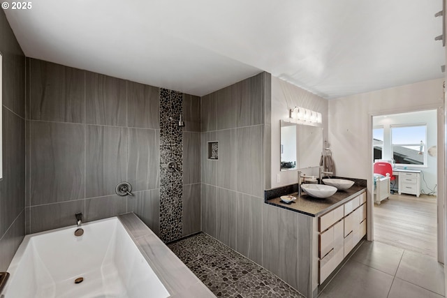 bathroom with tile patterned floors, vanity, and a bath