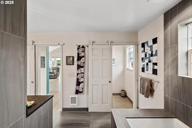 interior space with tile patterned flooring, plenty of natural light, and a barn door