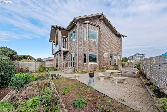 rear view of property featuring a patio area and a balcony