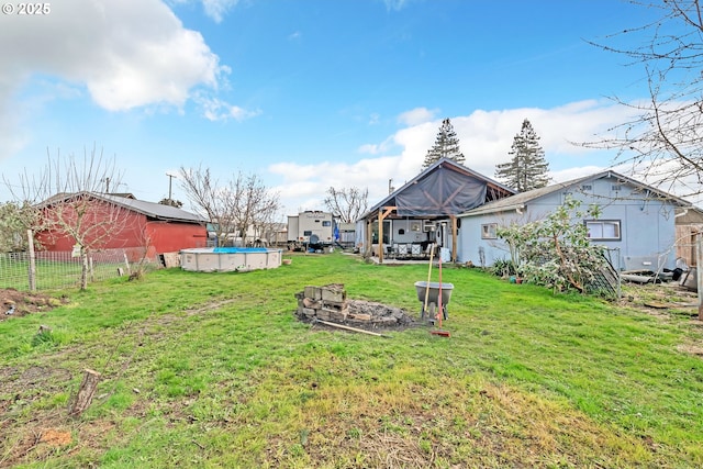 view of yard with an outdoor fire pit, fence, and a fenced in pool