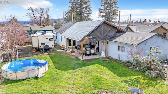 rear view of property with a lawn, a patio area, a residential view, and a covered pool