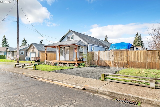 view of front of home featuring a porch, fence, and a gate