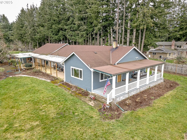 view of front of property with covered porch, roof with shingles, fence, and a front lawn