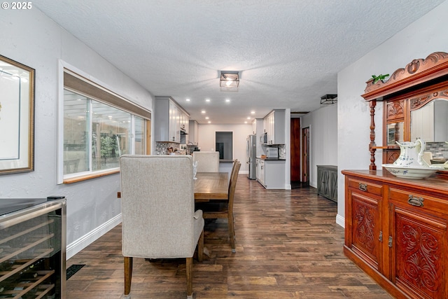 dining space with a textured ceiling, baseboards, and dark wood-style flooring