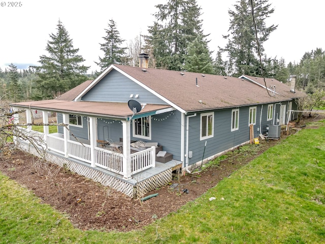 back of house with roof with shingles, a lawn, and cooling unit