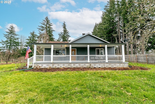 country-style home featuring a porch, a front lawn, and fence