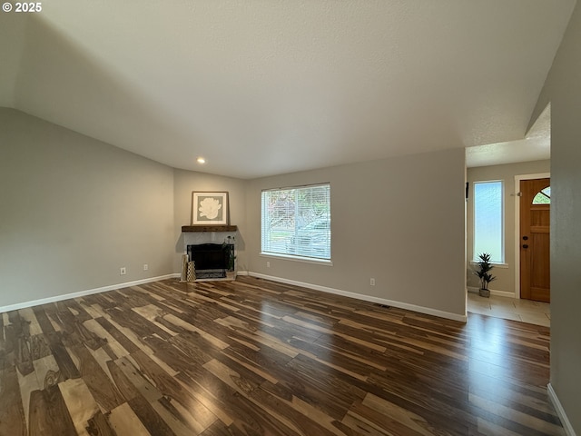 18294 SW Bergs Ct, Beaverton, OR 97003 - unfurnished living room with dark wood finished floors, vaulted ceiling, baseboards, a fireplace, and recessed lighting