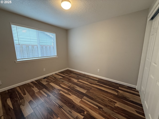 18294 SW Bergs Ct, Beaverton, OR 97003 - unfurnished bedroom featuring a closet, a textured ceiling, dark wood-style floors, and baseboards