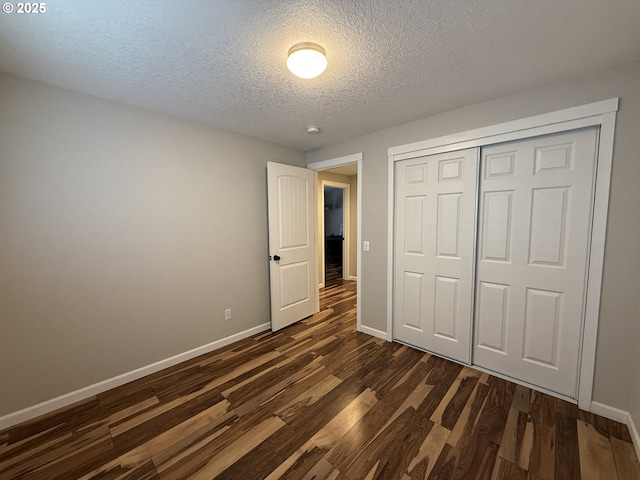 18294 SW Bergs Ct, Beaverton, OR 97003 - unfurnished bedroom with baseboards, a textured ceiling, dark wood-type flooring, and a closet