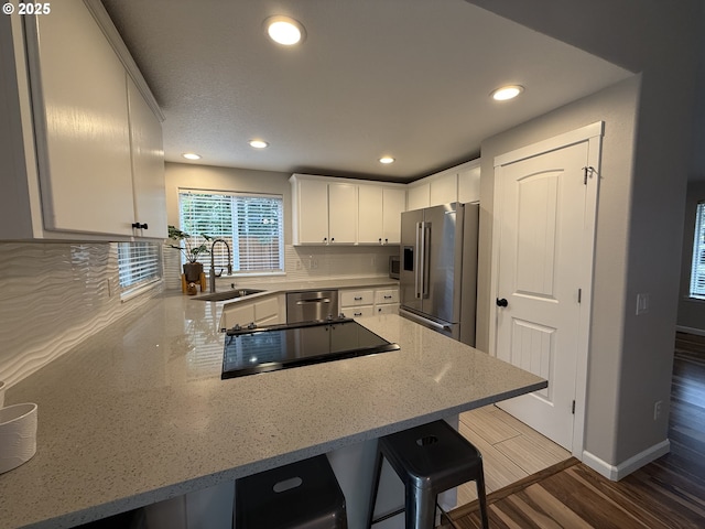 18294 SW Bergs Ct, Beaverton, OR 97003 - kitchen featuring appliances with stainless steel finishes, a sink, a peninsula, recessed lighting, and white cabinets