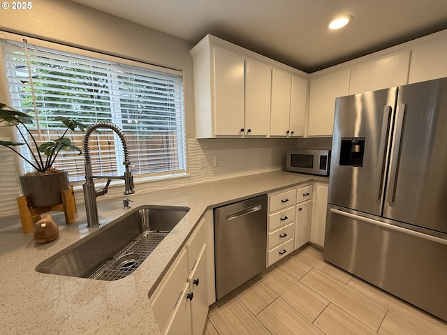 18294 SW Bergs Ct, Beaverton, OR 97003 - kitchen with appliances with stainless steel finishes, a sink, white cabinets, backsplash, and recessed lighting