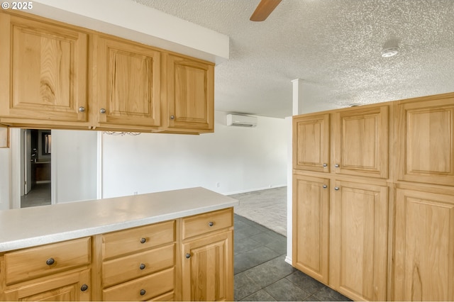 kitchen with an AC wall unit, light countertops, dark carpet, dark tile patterned floors, and a textured ceiling