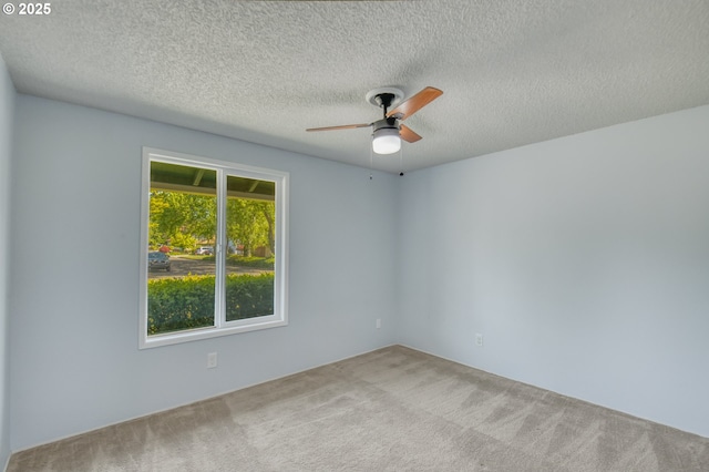 carpeted empty room with a ceiling fan and a textured ceiling