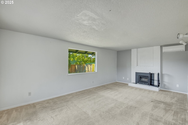 unfurnished living room with an AC wall unit, light colored carpet, a textured ceiling, and baseboards
