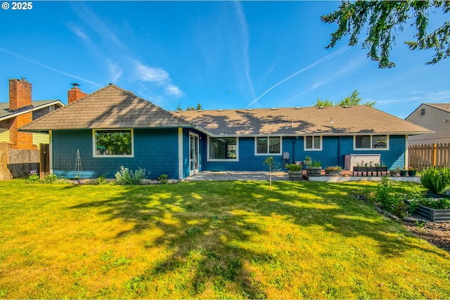 rear view of property featuring a patio, a chimney, and roof with shingles