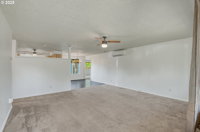 carpeted empty room with an AC wall unit, ceiling fan, a textured ceiling, and baseboards