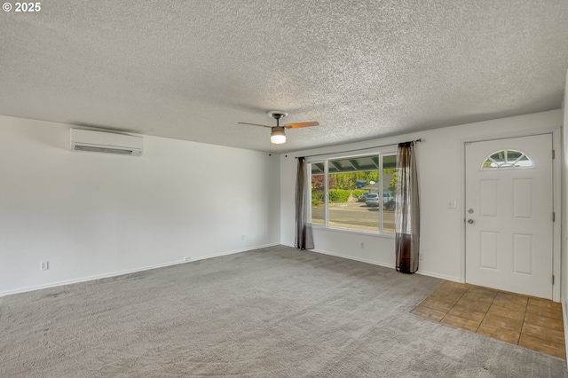 entrance foyer with a wall mounted AC, carpet flooring, a ceiling fan, a textured ceiling, and baseboards