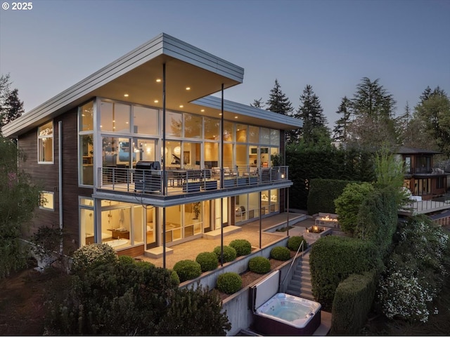 back of property with a patio, a jacuzzi, and a balcony