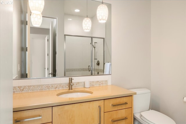 full bathroom with toilet, tiled shower, and vanity