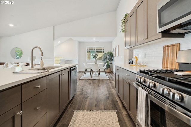 kitchen featuring dark wood finished floors, a sink, stainless steel appliances, and light countertops