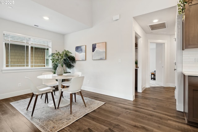 dining space with dark wood-type flooring, visible vents, and baseboards